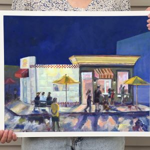 a framed print of a painting is held on display, showing a dark blue night sky behind a glowing local diner and ice cream shop in Royal oak Mi